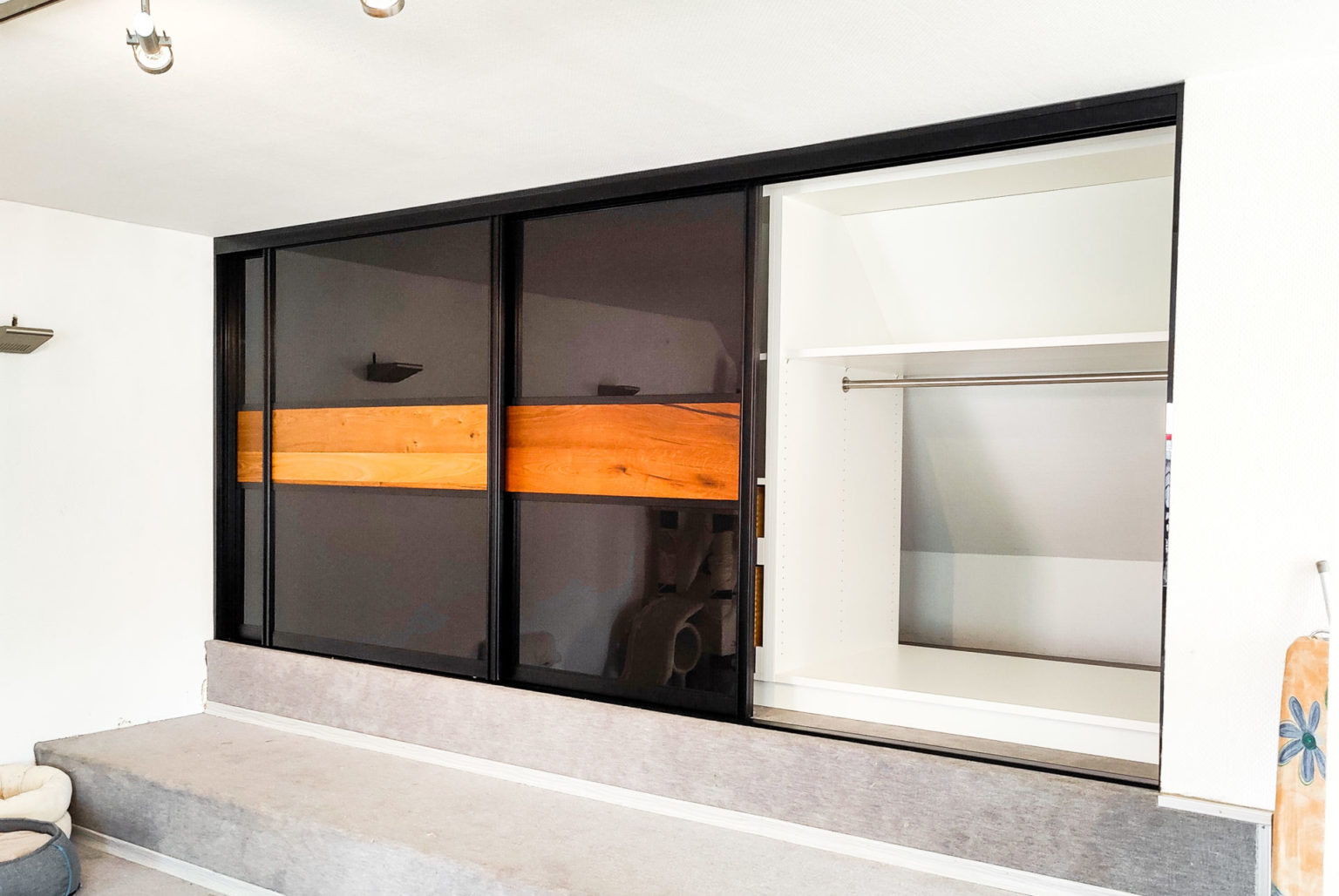 Black-and-white knee-high cabinet with sliding glass doors and wild oak