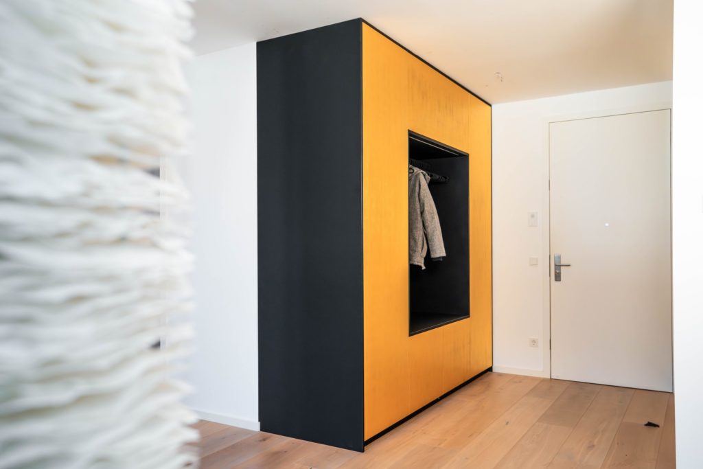 Wardrobe with seating niche in matt black with golden fronts