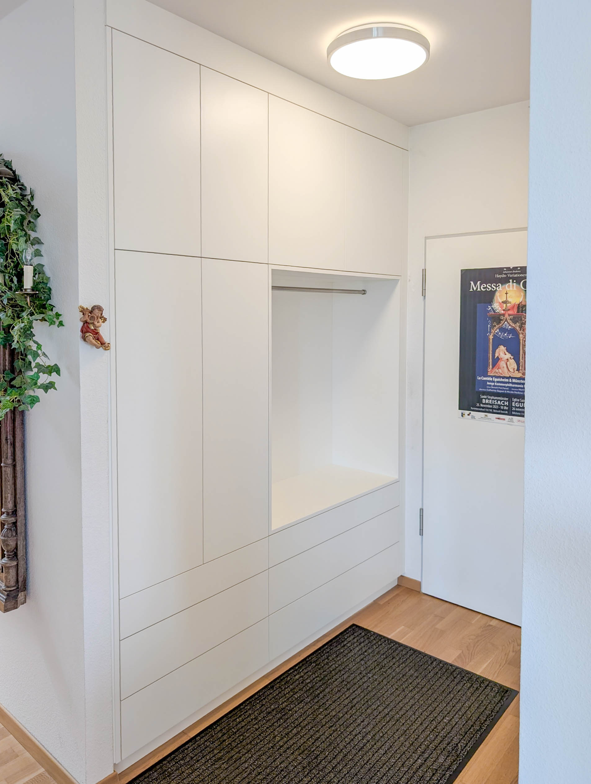 Custom-made wardrobe in white with open niche and integrated storage space in the hallway