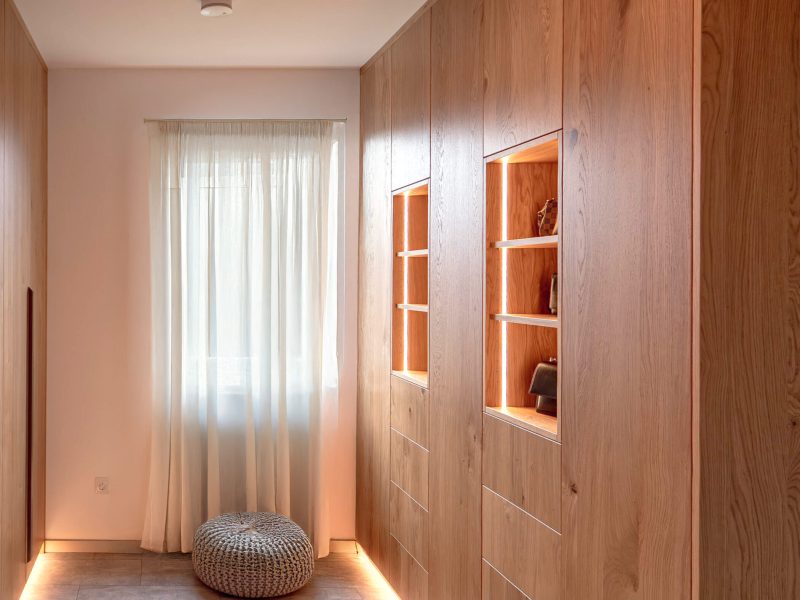 Custom-made wooden hallway cabinet with illuminated display cabinet compartments and integrated storage space