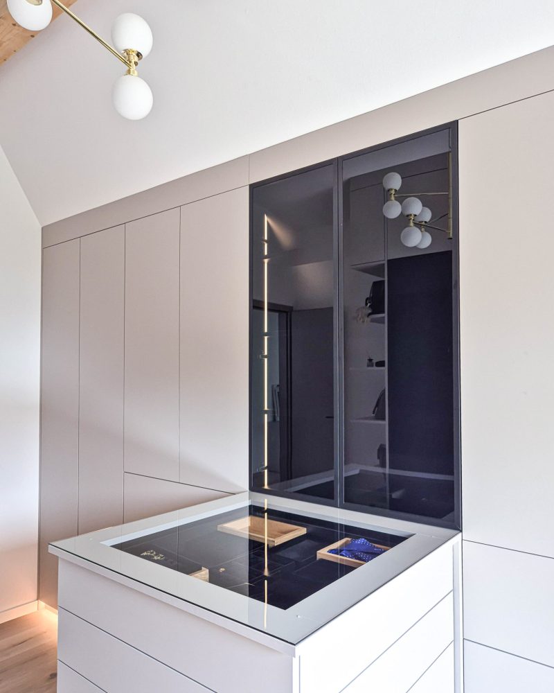 Custom-made dressing room with island, glass front and integrated lighting