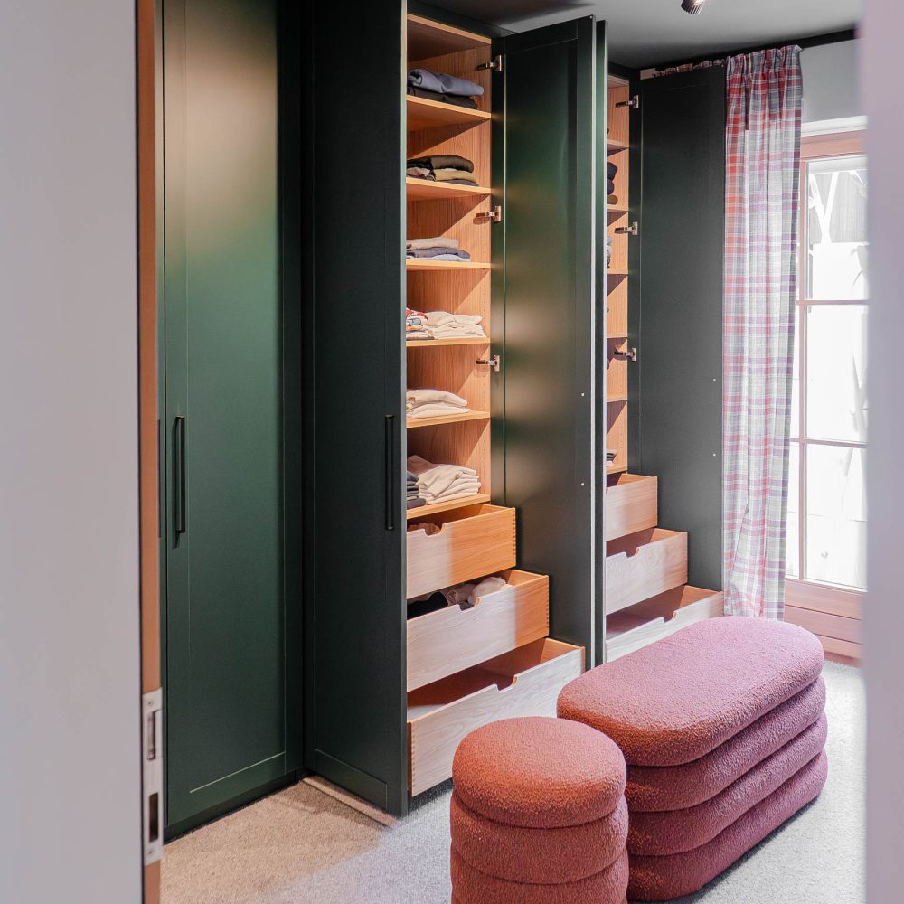 Custom-made dressing room with open green closet and integrated drawers