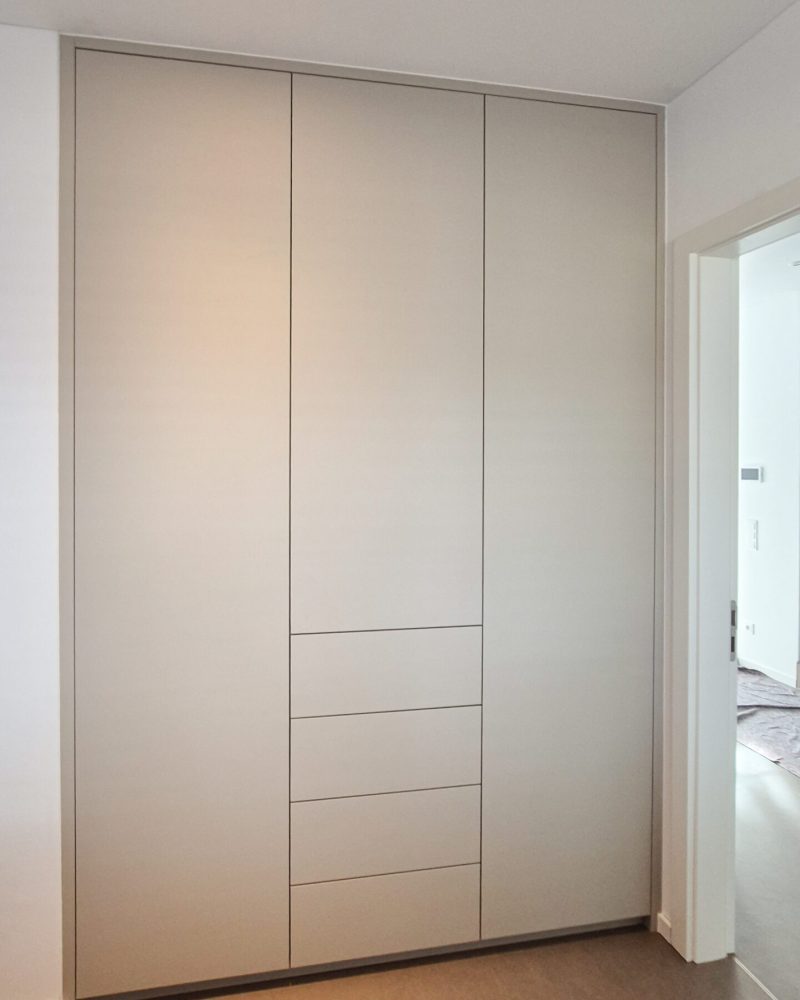 Custom-made built-in wardrobe in white with integrated drawers in the hallway