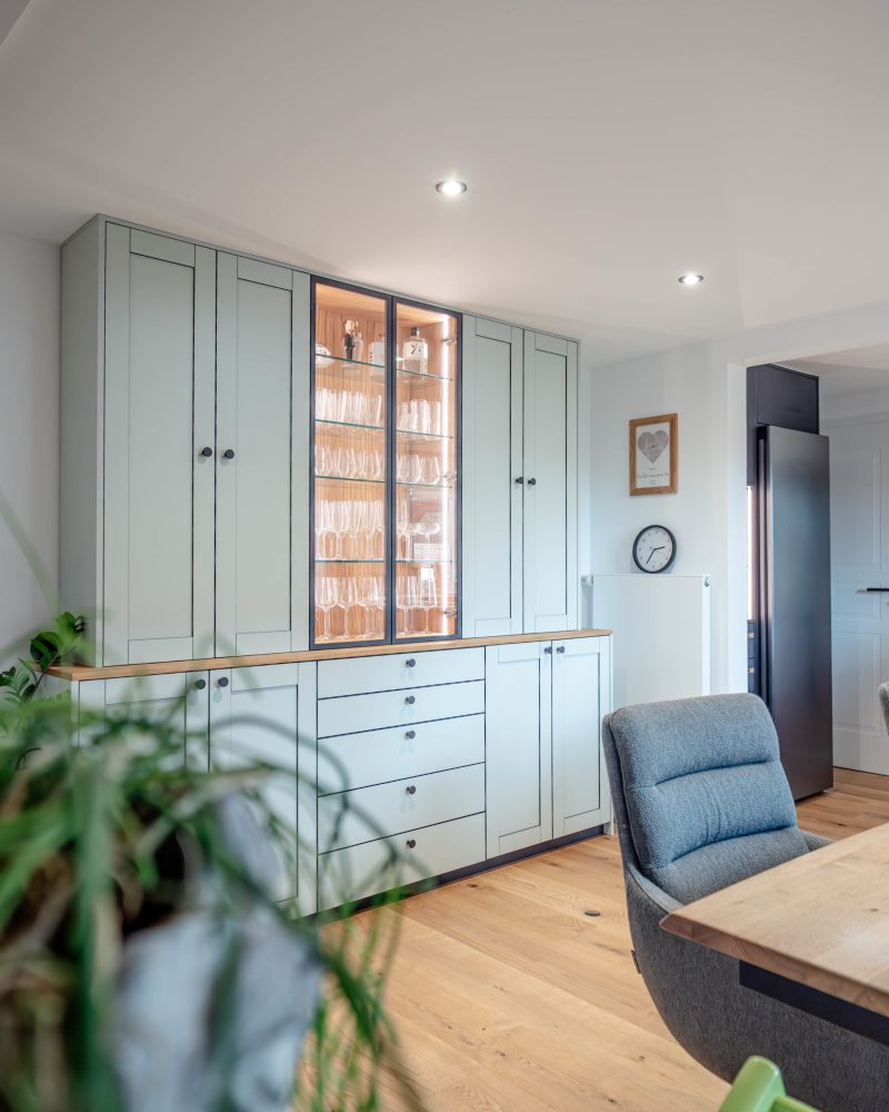 Sideboard in stone green with black edging, glass doors, and aluminum frame
