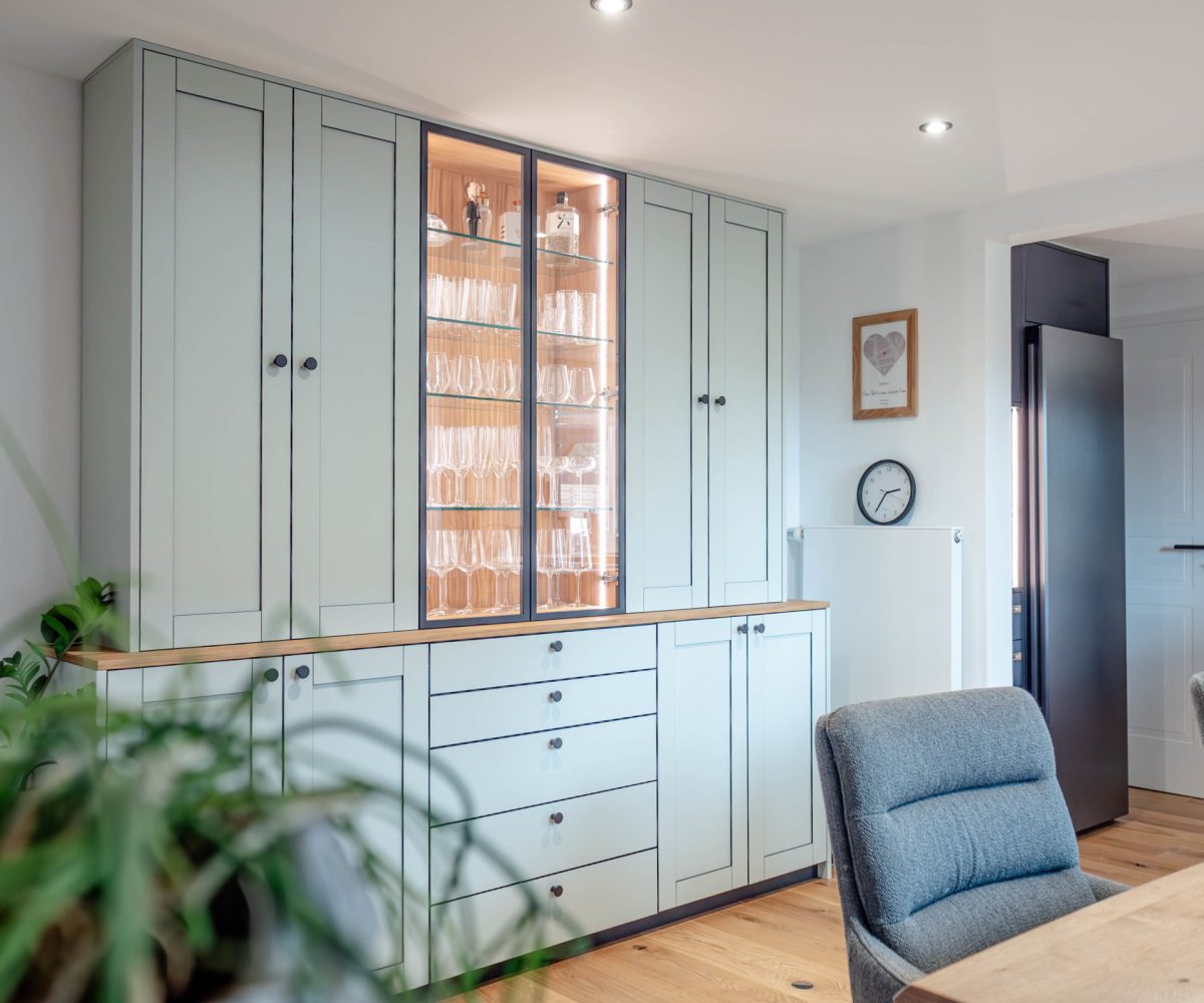 Sideboard in stone green with black edging, glass doors, and aluminum frame