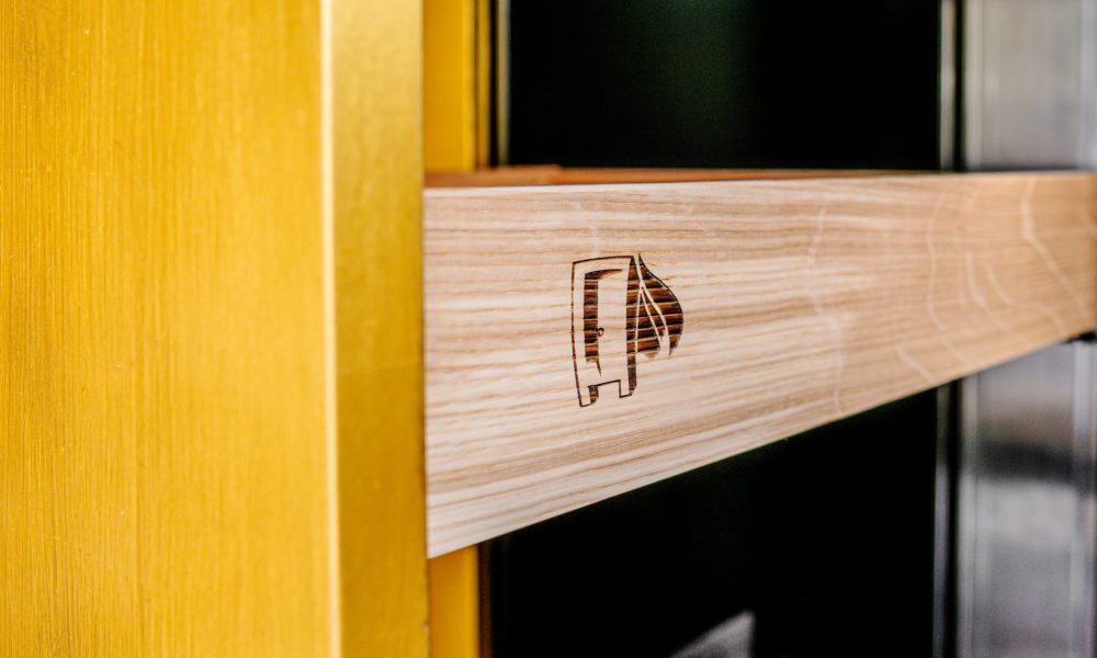 Einbauschrank mit goldenen Fronten Detailaufnahme Logo