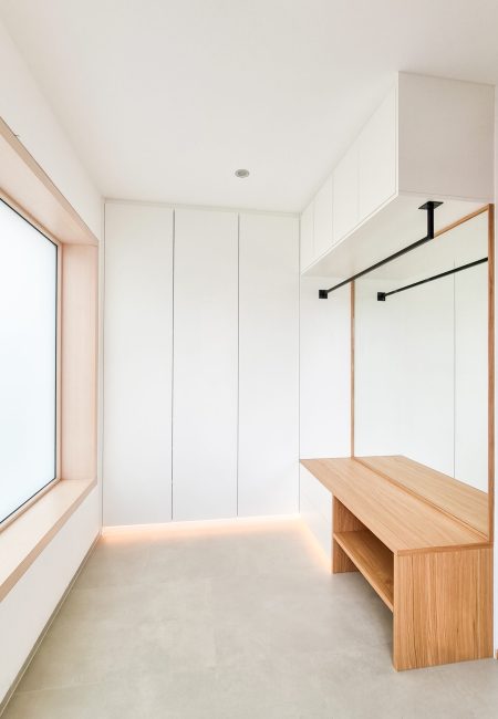White coat rack with a bench and a black coat rod