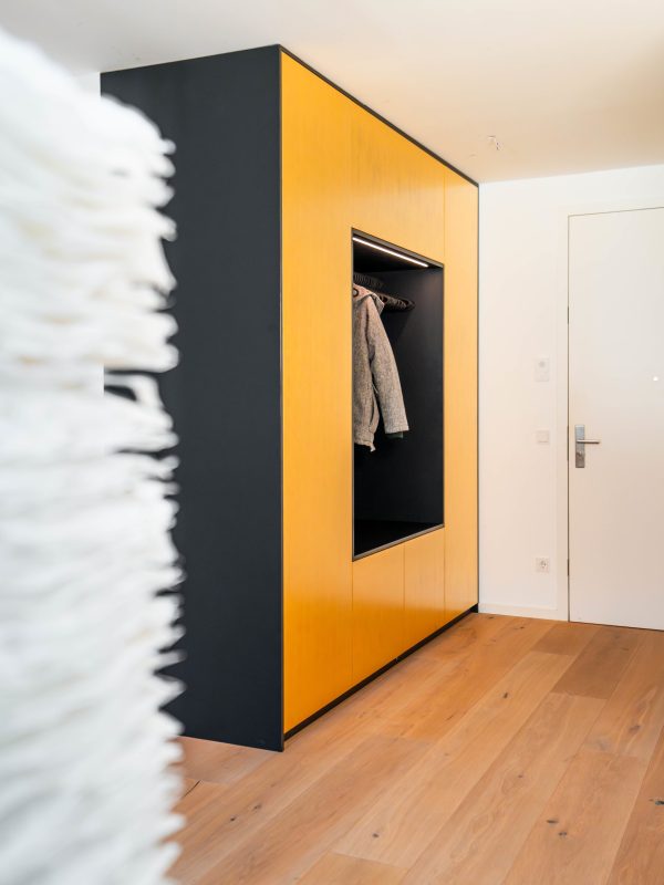 Custom-made wardrobe with open niche in gold and anthracite in a modern hallway