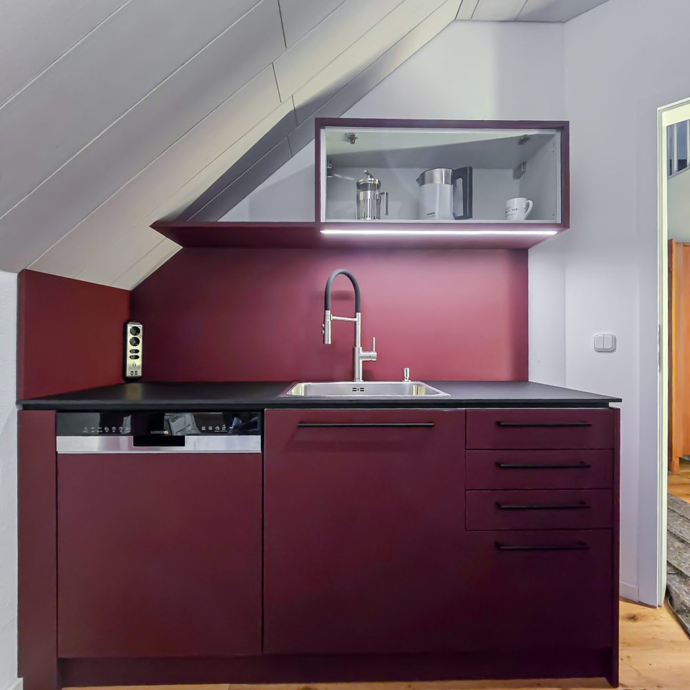 Burgundy red fitted kitchen with LED and plenty of storage space