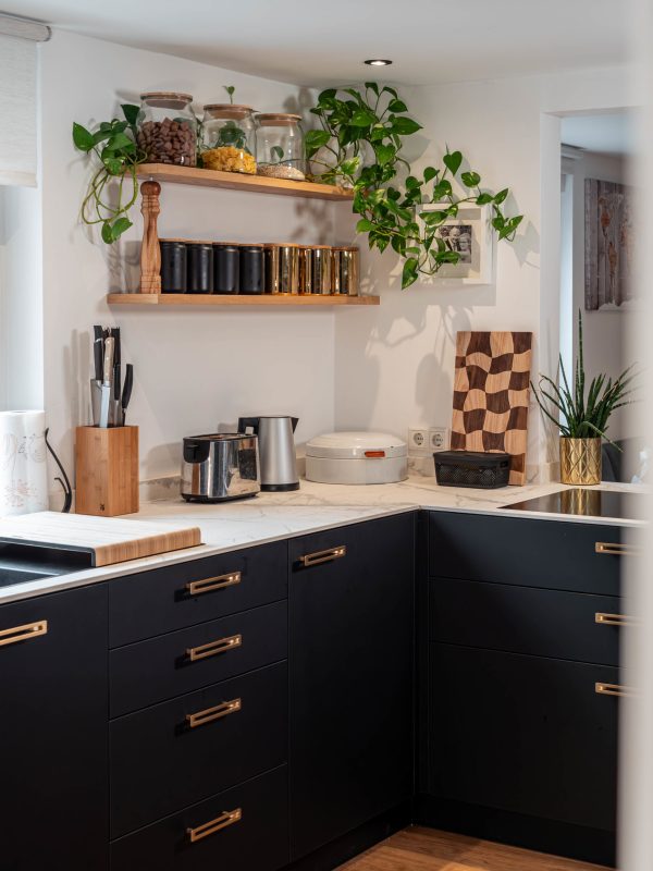 Matt black kitchen with golden handles and worktop in white granite