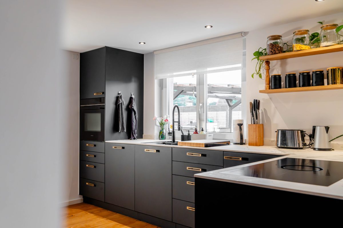 Matt black kitchen with integrated wine cabinet