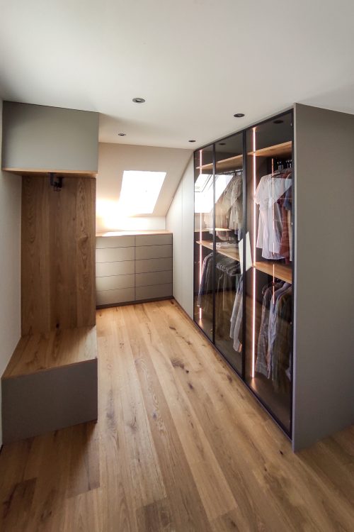 Walk-in closet in gray with glass doors and a seating niche