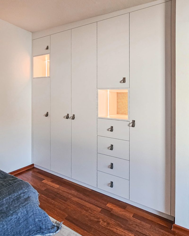 Custom-made built-in wardrobe in white with illuminated niches and integrated drawers